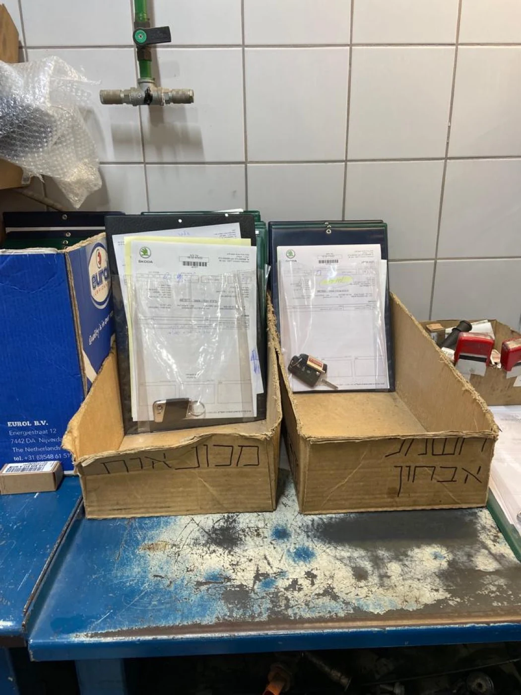 Status tracked by cardboard box — clipboards and car keys filed together