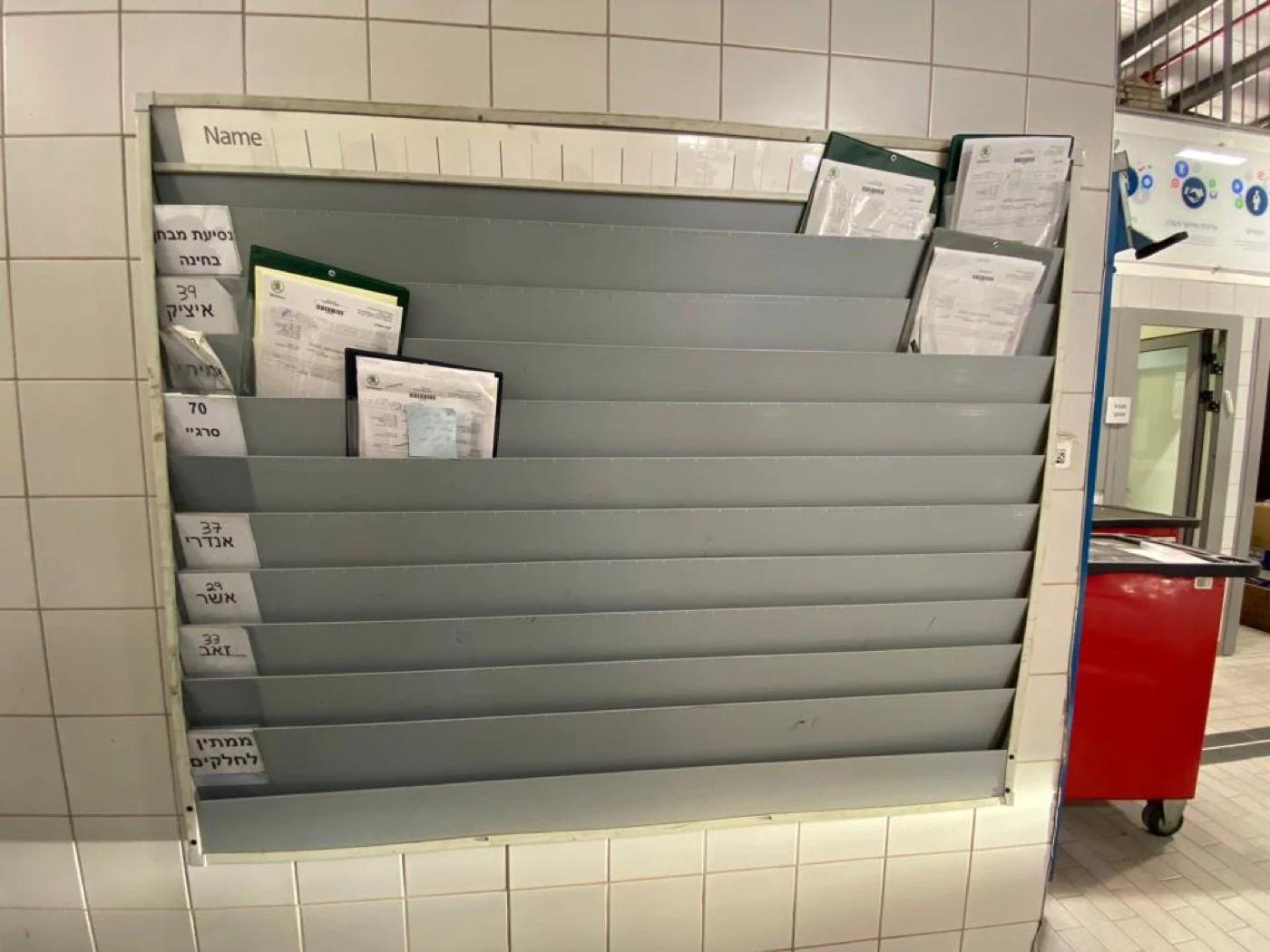 The manager's board before the board — a wall rack, one paper slot per mechanic