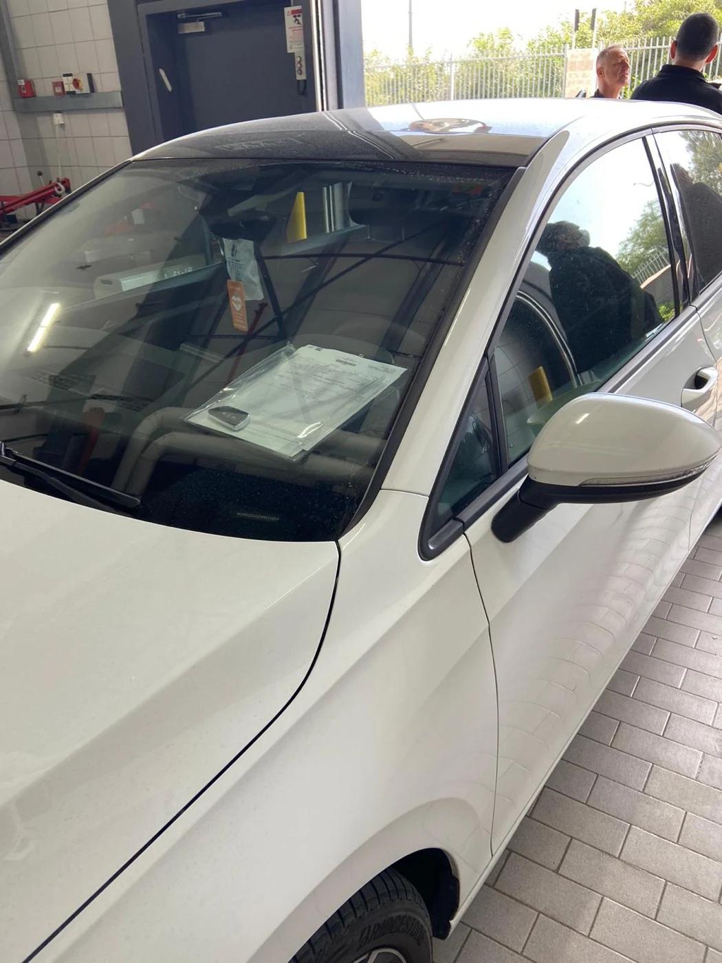 The job ticket filed under the windshield wiper, key on top